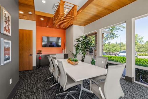 A conference room with a long table and chairs.