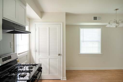 A kitchen with a stove and a door.
