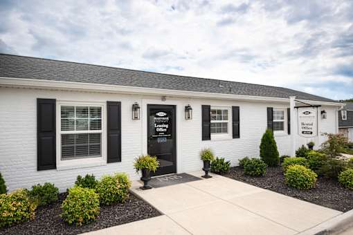 A white building with black shutters and a sign that reads "Beneficial Bank".