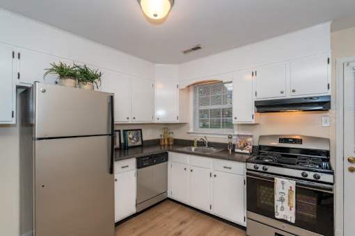 A kitchen with white cabinets and a stainless steel refrigerator.