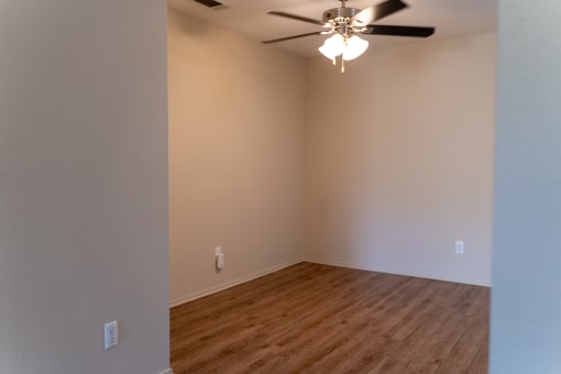 an empty living room with a ceiling fan and wood floors at Cowell Terrace Apartments, Concord California