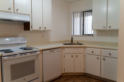 an empty kitchen with white cabinets and appliances and a sink at Cowell Terrace Apartments, Concord, 94518