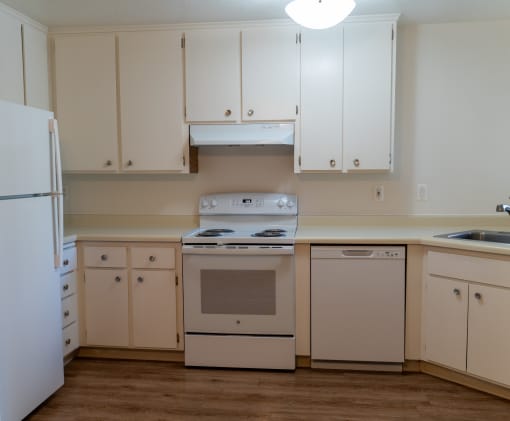an empty kitchen with white cabinets and a stove and refrigerator at Cowell Terrace Apartments, Concord, 94518