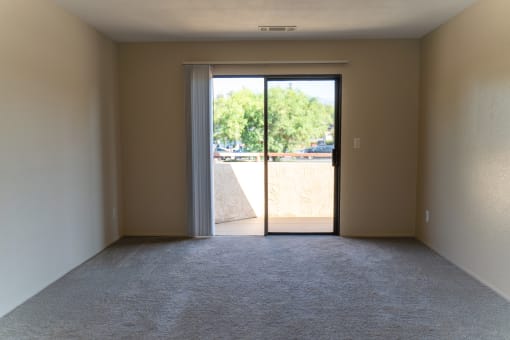 an empty living room with a door to a balcony at Cowell Terrace Apartments, Concord, CA