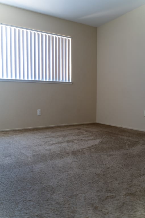 an empty room with a window and a carpeted floor at Cowell Terrace Apartments, Concord, CA