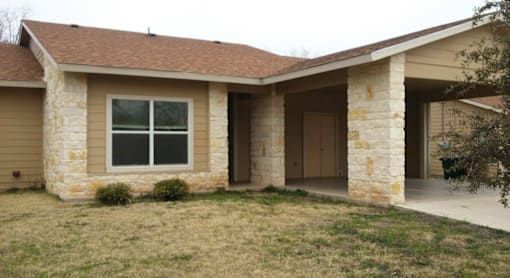A house with a brown roof and stone walls.