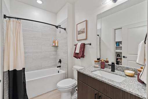 A bathroom with a white toilet, a sink, and a shower.