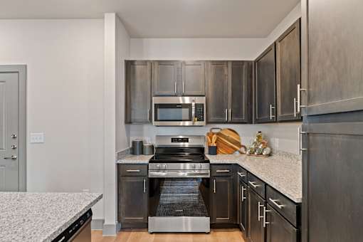 A modern kitchen with a stainless steel oven and microwave.