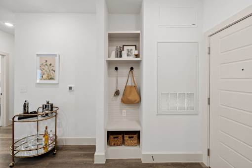 A white hallway with a bar cart and a door.