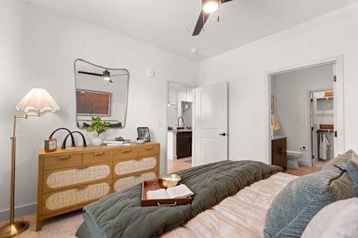 A bedroom with a bed, dresser, and mirror.