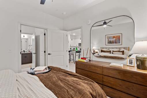 A bedroom with a bed, a dresser, and a mirror.