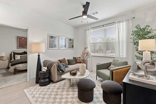 A living room with a grey sofa, a white coffee table, and a rug with a checkered pattern.