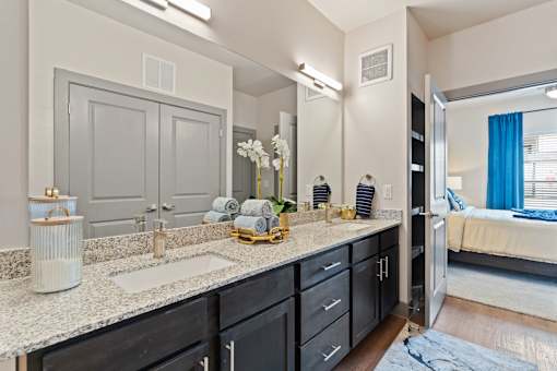 A bathroom with a sink, mirror, and a large cabinet.