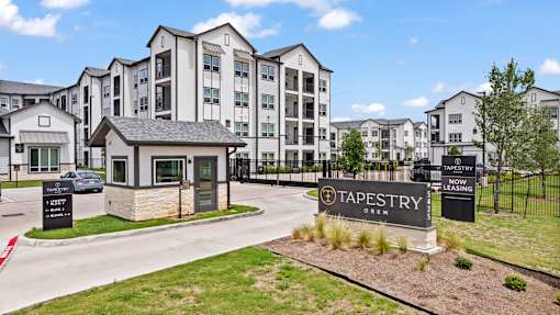 A sign for Tapestry Apartments is displayed in front of a building.