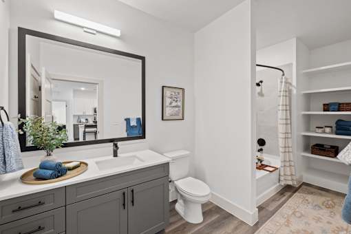 A bathroom with a white toilet, sink, and a mirror.