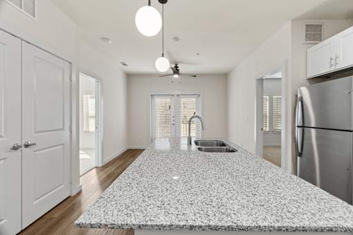 A kitchen with a white tile floor and a stainless steel refrigerator.