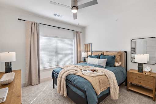 A bedroom with a large bed and a ceiling fan.