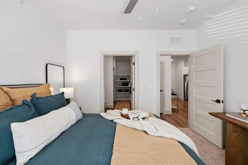A bedroom with a bed, a nightstand, and a closet.