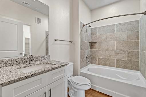 A bathroom with a white toilet, sink, and bathtub.