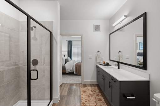 A bathroom with a walk-in shower, a sink, and a mirror.