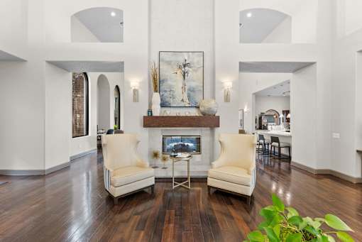 A living room with a fireplace and two chairs.