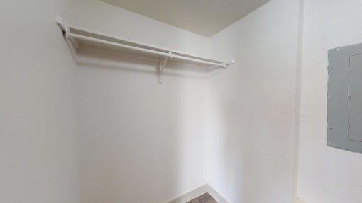 an empty room with a white wall and a white shelf on the wall