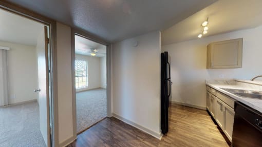 a kitchen and living room with a sink and a refrigerator