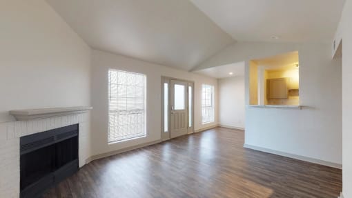 a living room with a fireplace and a door and a lot of natural light