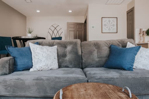 a living room with a gray couch and blue pillows