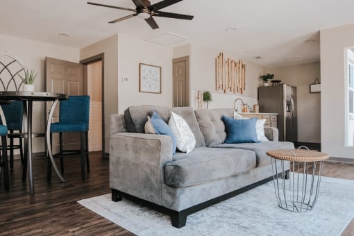 a living room with a gray couch and a dining room table