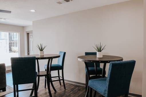 a dining room with three tables and blue chairs