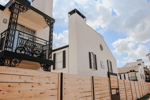 a white building with a wooden fence in front of it