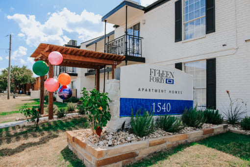 a building with a sign and balloons in front of it