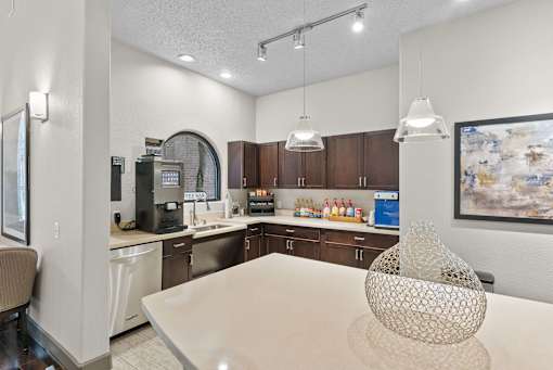 A modern kitchen with a dining table and a coffee machine.