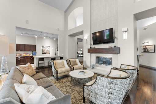 A living room with a grey couch and a fireplace.