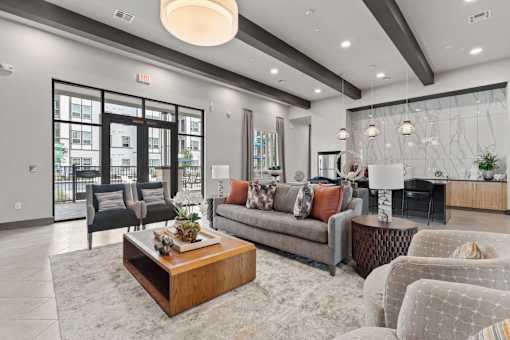 A modern living room with a large grey sofa, a wooden coffee table, and a fireplace.
