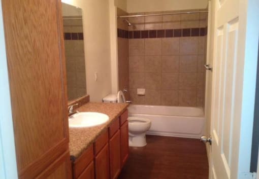 A bathroom with a toilet, sink, and bathtub.