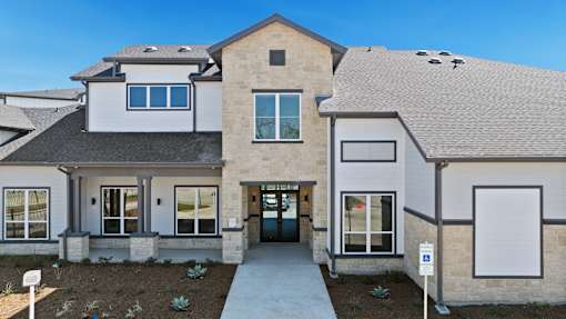 A modern house with a grey roof and a white garage door.