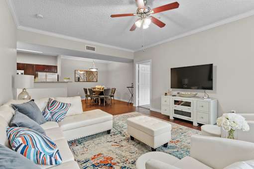 A living room with a white couch and a ceiling fan.