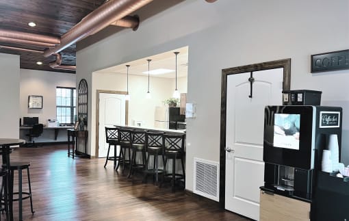 a bar area with a bar stool and a coffee machine