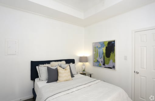 a bedroom with a bed and a painting on the wall