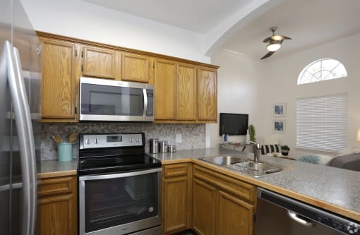 a kitchen with a stove sink and microwave and wooden cabinets
