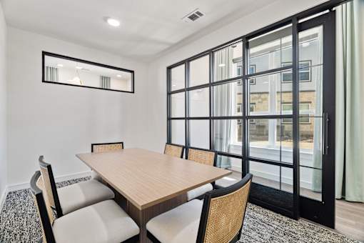 A dining room with a wooden table and chairs.