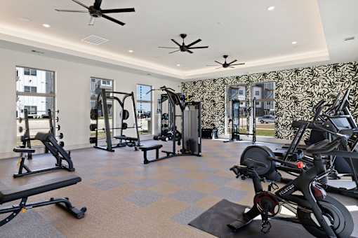 A spacious gym with a variety of equipment including treadmills, weights, and exercise bikes.