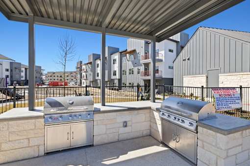 A barbecue grill is on a patio with a sign that says "No Living.".