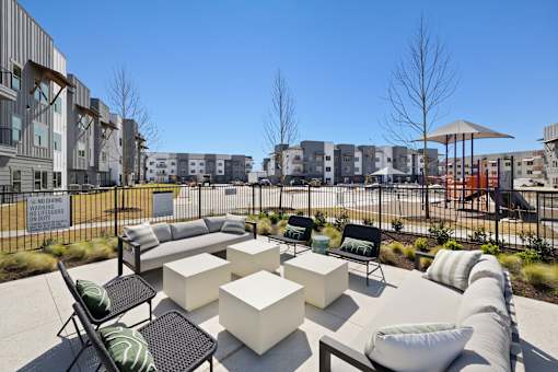 A modern outdoor seating area with white and black furniture.
