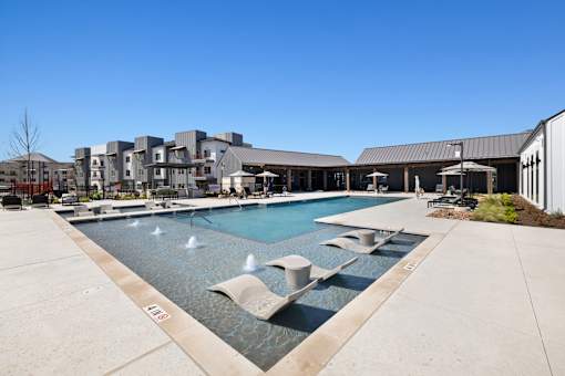 A large swimming pool with a fountain in the middle of it.