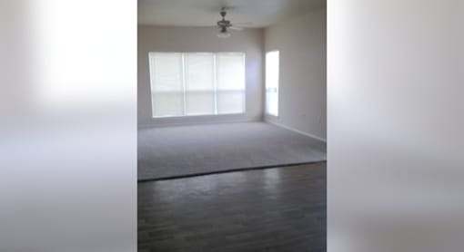 A room with a large window and a wooden floor.