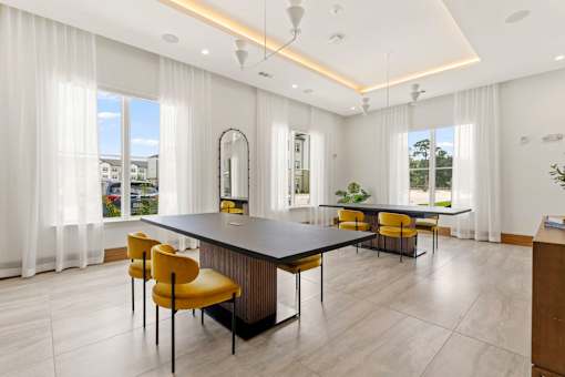 A modern dining room with a large table and yellow chairs.