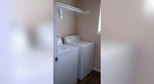 A small white laundry room with a washer and dryer.